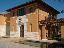 custom home with bridge to front door over water features in front yard